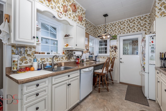 kitchen featuring white cabinets, white appliances, decorative light fixtures, and sink