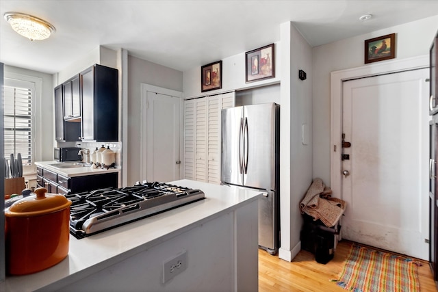 kitchen with stainless steel appliances, light hardwood / wood-style floors, and sink