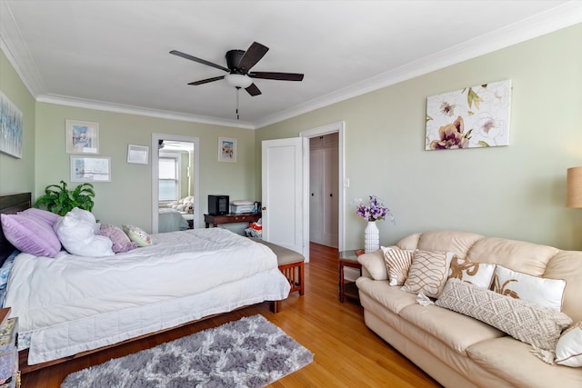 bedroom with ceiling fan, light wood-type flooring, and crown molding