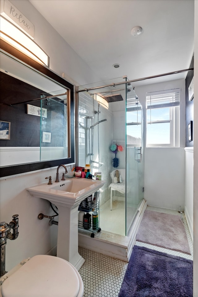 bathroom featuring a shower with shower door and toilet