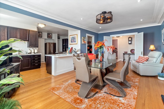 dining area featuring ornamental molding and light hardwood / wood-style flooring