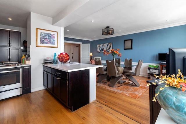 kitchen featuring stainless steel stove, ornamental molding, light hardwood / wood-style flooring, and kitchen peninsula