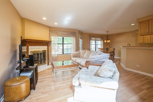 living room featuring light hardwood / wood-style floors and a tile fireplace