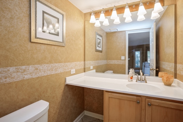 bathroom with tile patterned flooring, vanity, and toilet