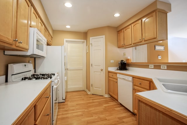 kitchen featuring white appliances, sink, and light hardwood / wood-style flooring