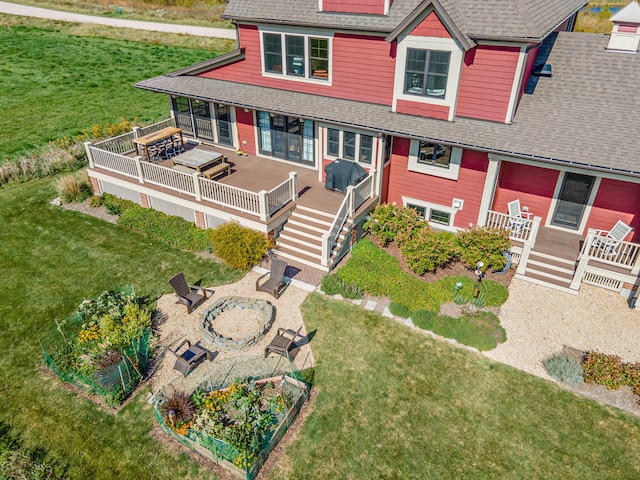 view of front of home featuring an outdoor fire pit, a front yard, and a wooden deck