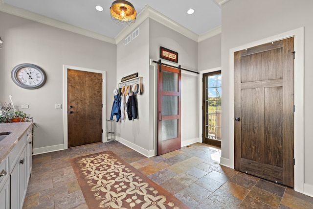 entryway with crown molding and a barn door