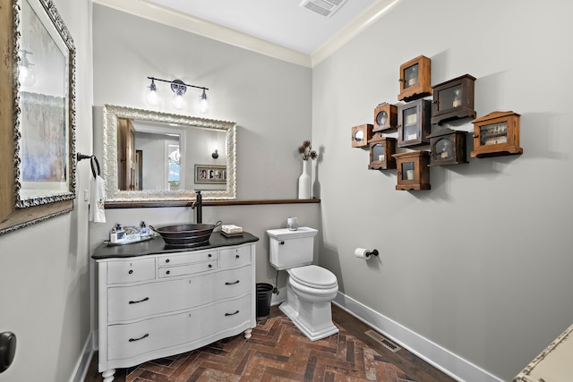 bathroom with vanity, toilet, ornamental molding, and parquet floors