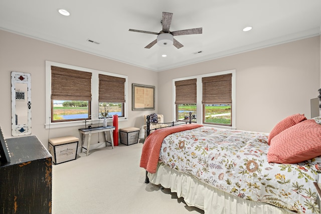 bedroom featuring multiple windows, light colored carpet, crown molding, and ceiling fan