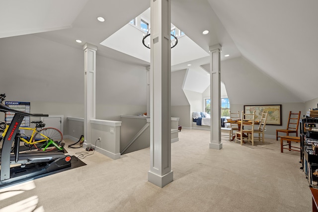 interior space featuring vaulted ceiling with skylight and light colored carpet