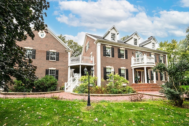 colonial-style house with a balcony and a front yard