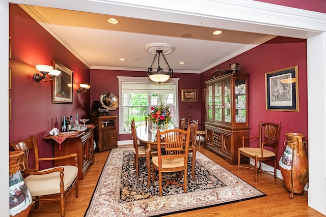 dining area with wood-type flooring and ornamental molding