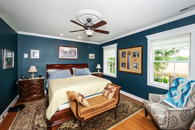 bedroom with ceiling fan, ornamental molding, and hardwood / wood-style floors