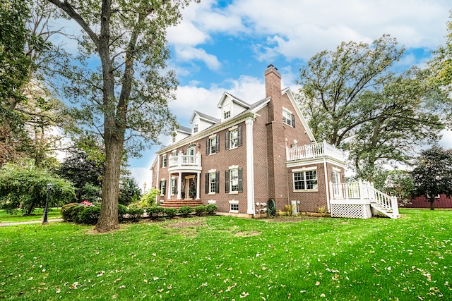 back of property featuring a lawn and a balcony