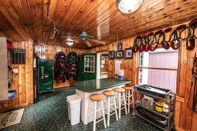 kitchen with ceiling fan, wood walls, kitchen peninsula, wooden ceiling, and a breakfast bar