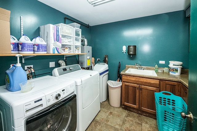 washroom featuring cabinets, water heater, sink, and washing machine and dryer