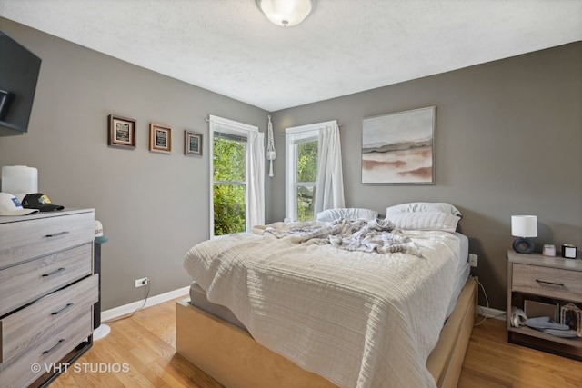 bedroom featuring light wood-type flooring and a textured ceiling