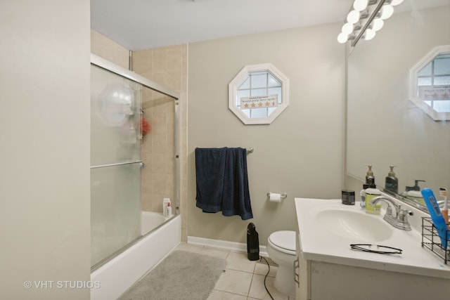 full bathroom featuring tile patterned flooring, combined bath / shower with glass door, vanity, and toilet