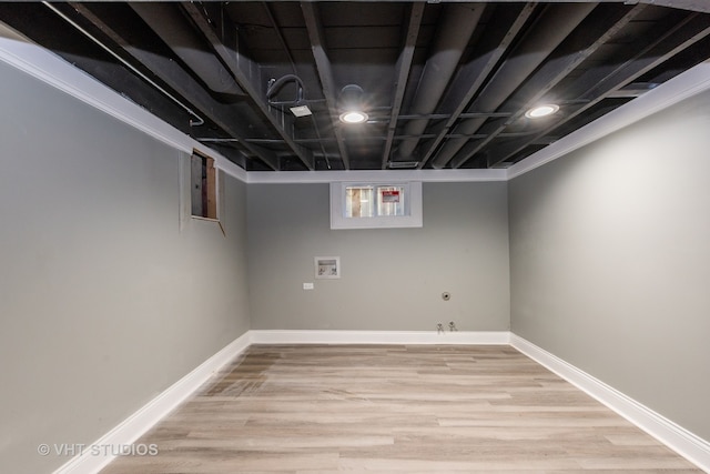 basement featuring crown molding and light wood-type flooring