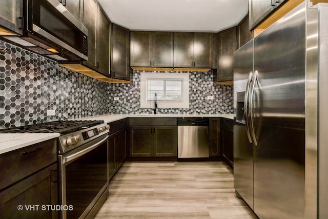 kitchen with light hardwood / wood-style floors, decorative backsplash, dark brown cabinetry, and stainless steel appliances