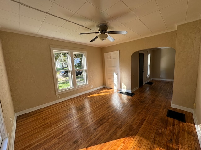 spare room with ornamental molding, ceiling fan, and dark hardwood / wood-style floors