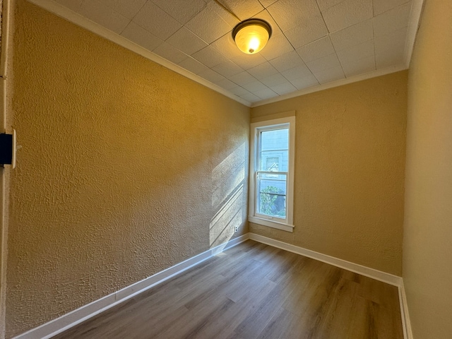 unfurnished room featuring ornamental molding and hardwood / wood-style floors