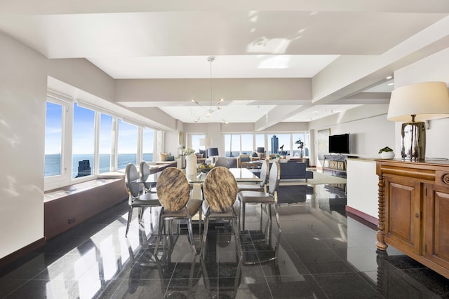 dining area featuring a notable chandelier and a water view