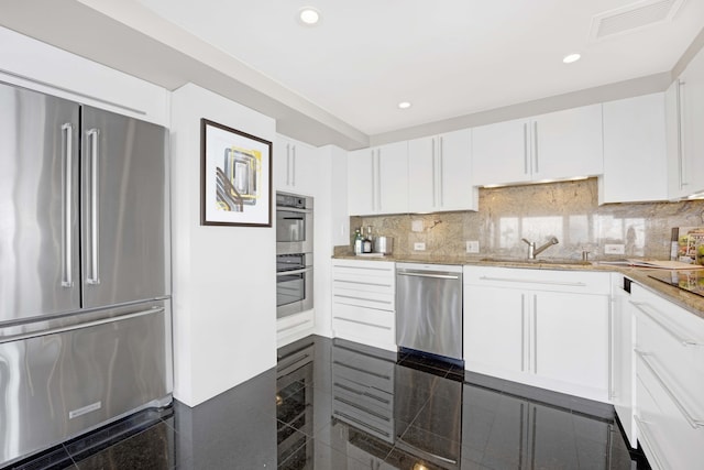 kitchen featuring tasteful backsplash, stainless steel appliances, and white cabinets