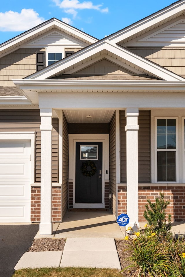 entrance to property with a garage and covered porch