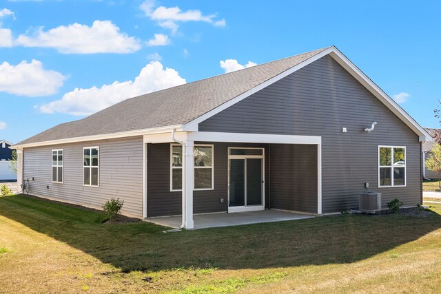 back of house featuring a yard, central AC unit, and a patio area