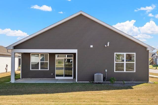 rear view of house featuring a lawn and central air condition unit