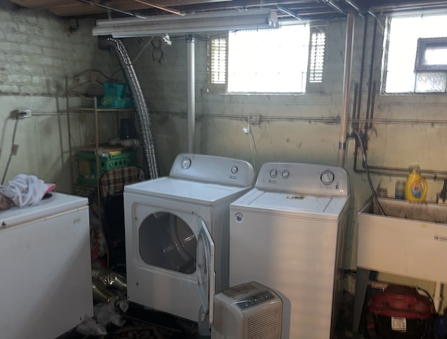 washroom with independent washer and dryer and sink