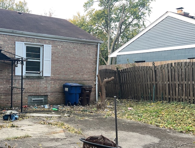 view of property exterior with a patio area and an outdoor fire pit