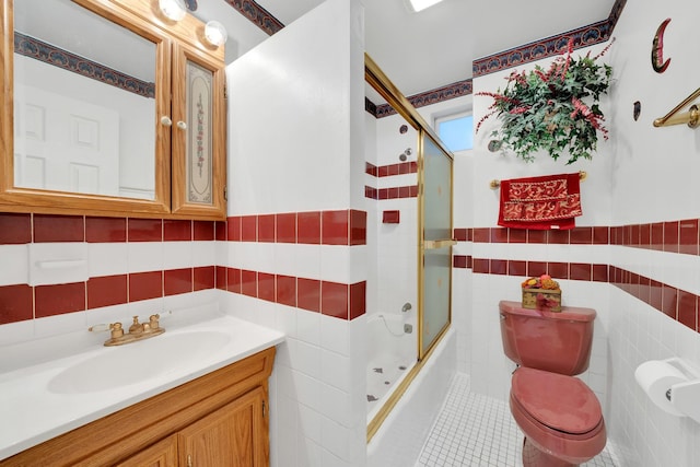 full bathroom with vanity, tile walls, shower / bath combination with glass door, and toilet