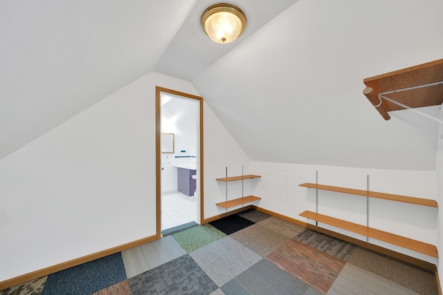 bonus room with carpet flooring and vaulted ceiling