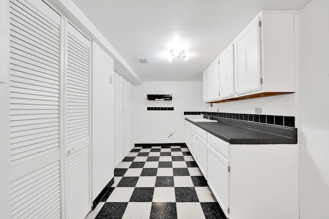 kitchen featuring sink and white cabinets