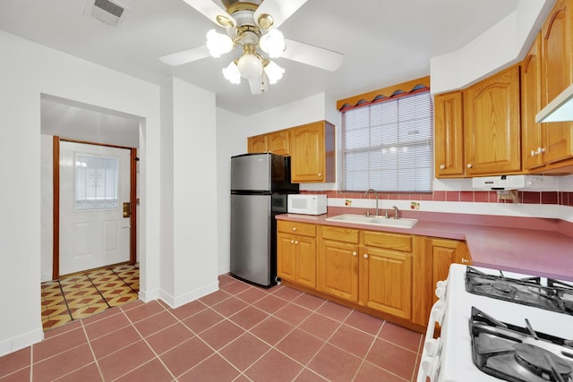 kitchen with a healthy amount of sunlight, sink, ceiling fan, and white appliances