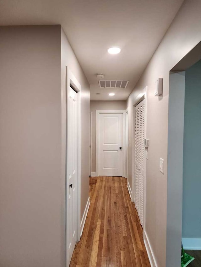 hallway with hardwood / wood-style floors