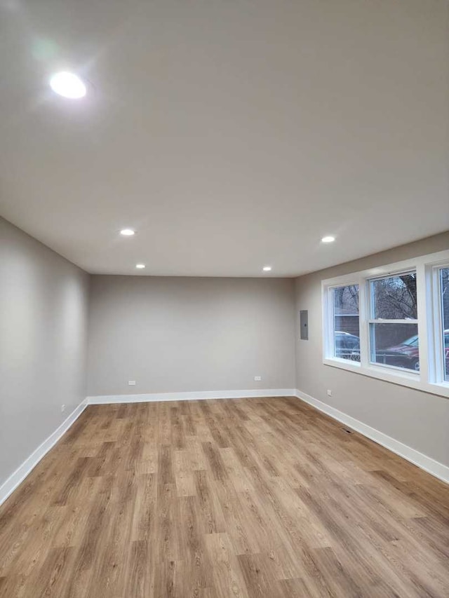 empty room featuring electric panel and light wood-type flooring