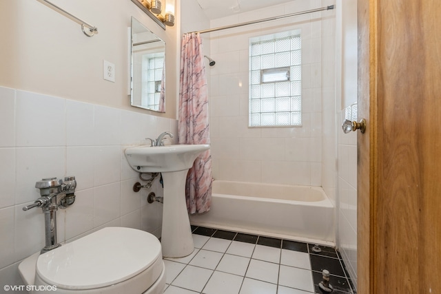 bathroom featuring tile patterned flooring, toilet, tile walls, and shower / bath combo with shower curtain