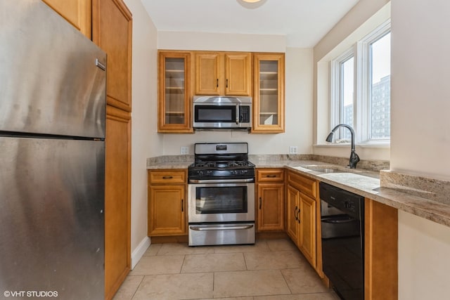 kitchen featuring light tile patterned flooring, light stone counters, sink, and appliances with stainless steel finishes