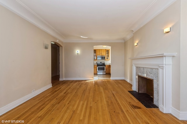 unfurnished living room featuring crown molding, light hardwood / wood-style flooring, and a premium fireplace