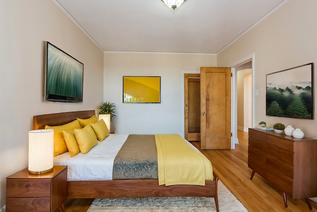 bedroom with hardwood / wood-style flooring and ornamental molding