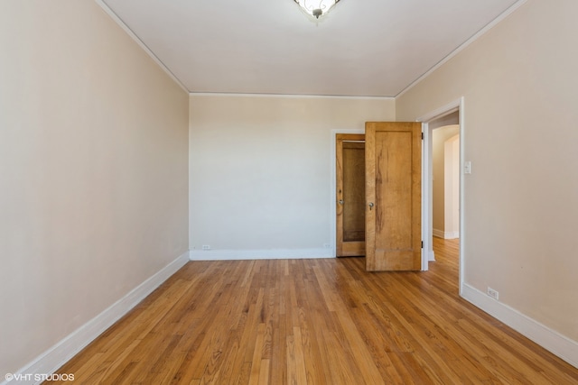 empty room with light hardwood / wood-style floors and ornamental molding