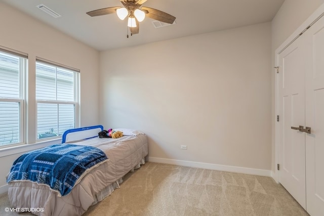 carpeted bedroom with ceiling fan and a closet