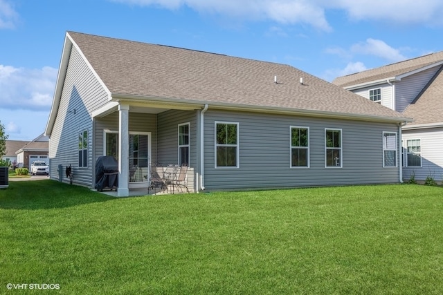 rear view of property with central AC, a patio area, and a lawn