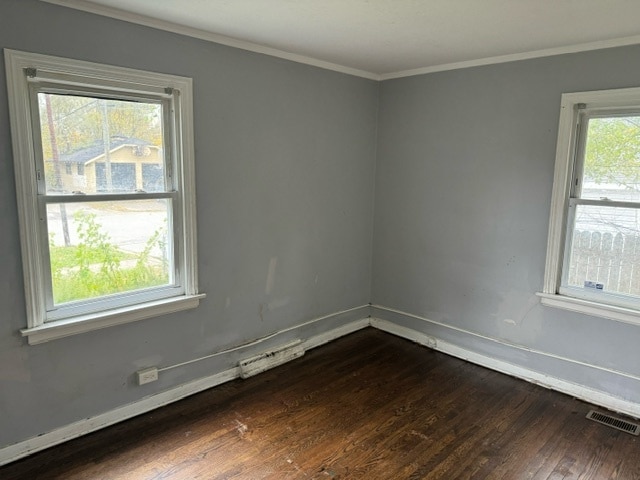 spare room featuring crown molding and dark hardwood / wood-style floors