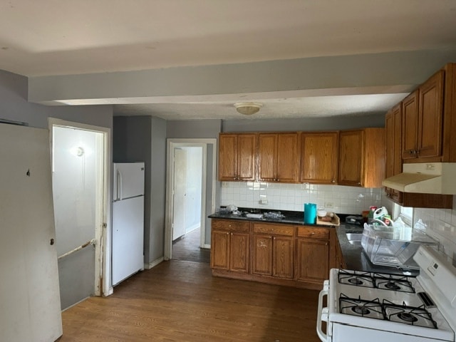 kitchen featuring white appliances, decorative backsplash, and light hardwood / wood-style flooring