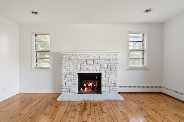 room details with baseboard heating, a fireplace, and hardwood / wood-style floors