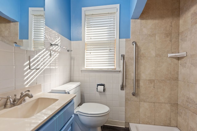 bathroom featuring tile walls, tiled shower, vanity, and toilet